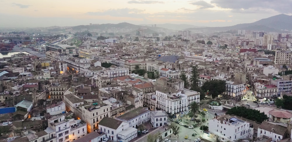 an aerial view of a city with mountains in the background