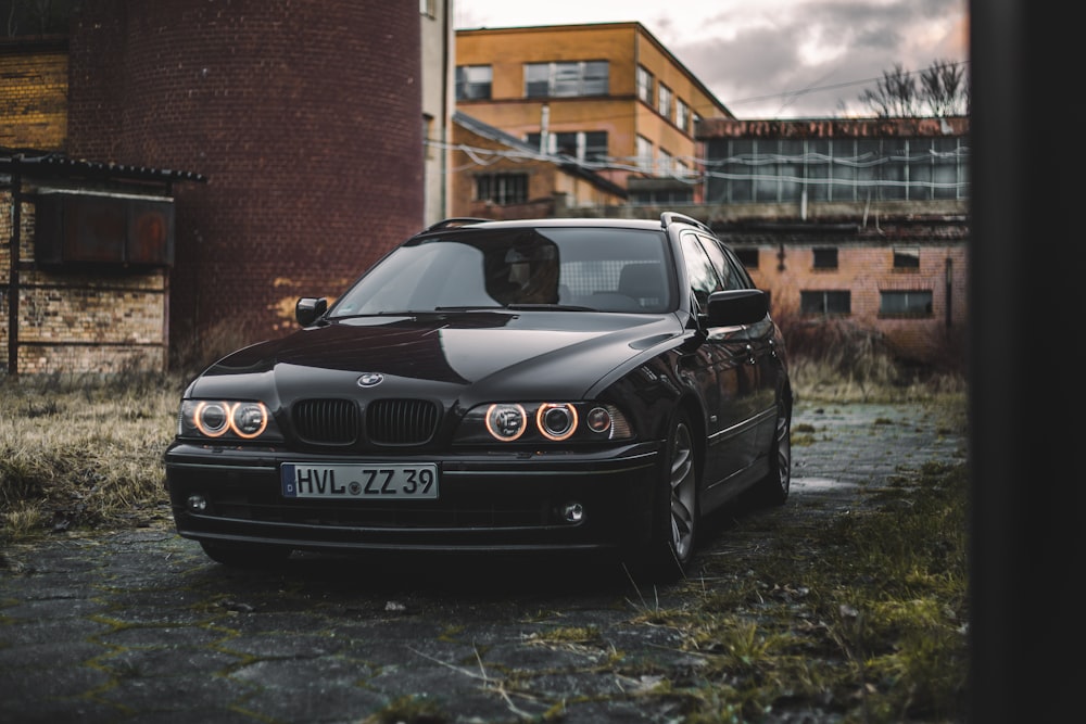 a black car parked in front of a brick building