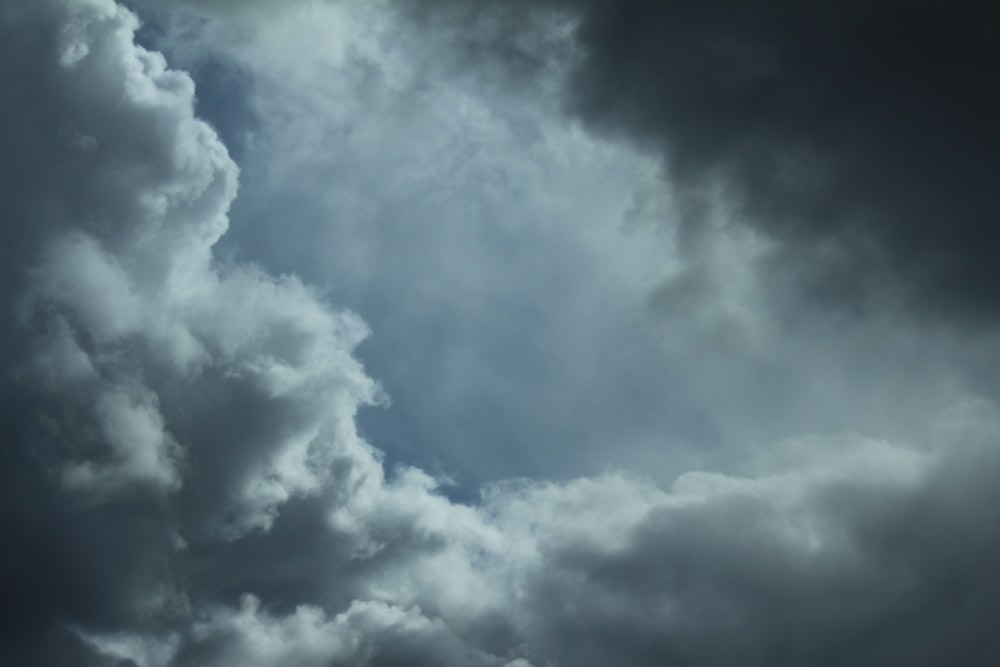 a plane flying through a cloudy sky on a cloudy day