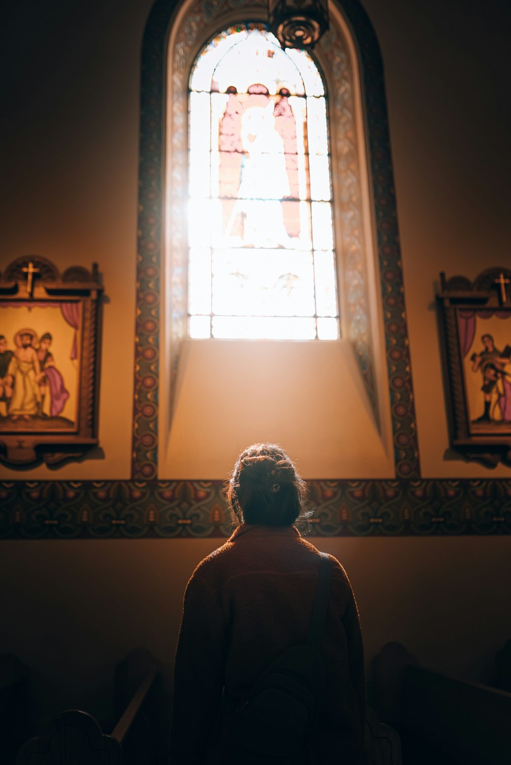 a woman standing in front of a stained glass window