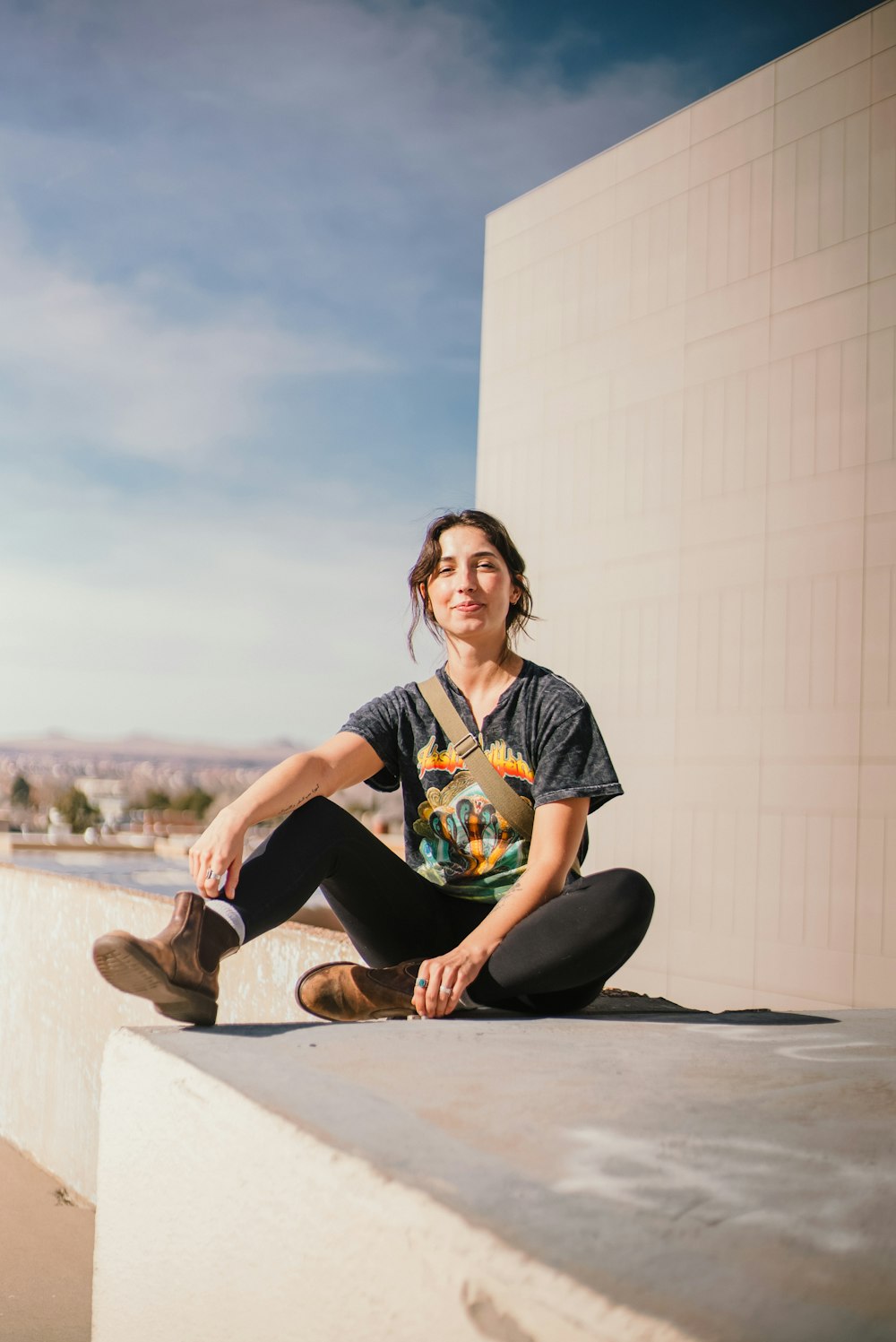 a woman sitting on a ledge with a skateboard