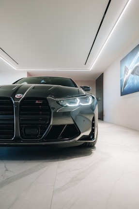 A sleek modern luxury vehicle parked in a minimalist showroom with deep charcoal walls.