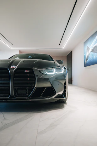 A sleek, modern luxury car showroom with polished floors and ambient lighting.