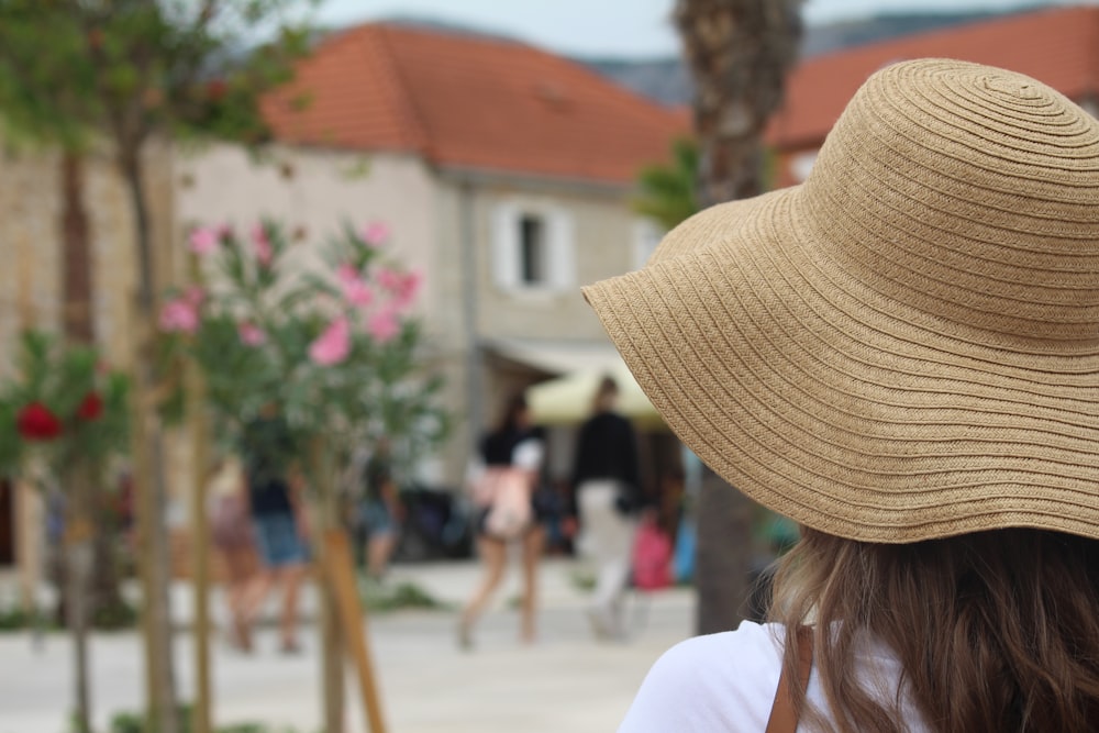 a woman wearing a tan hat and a white shirt