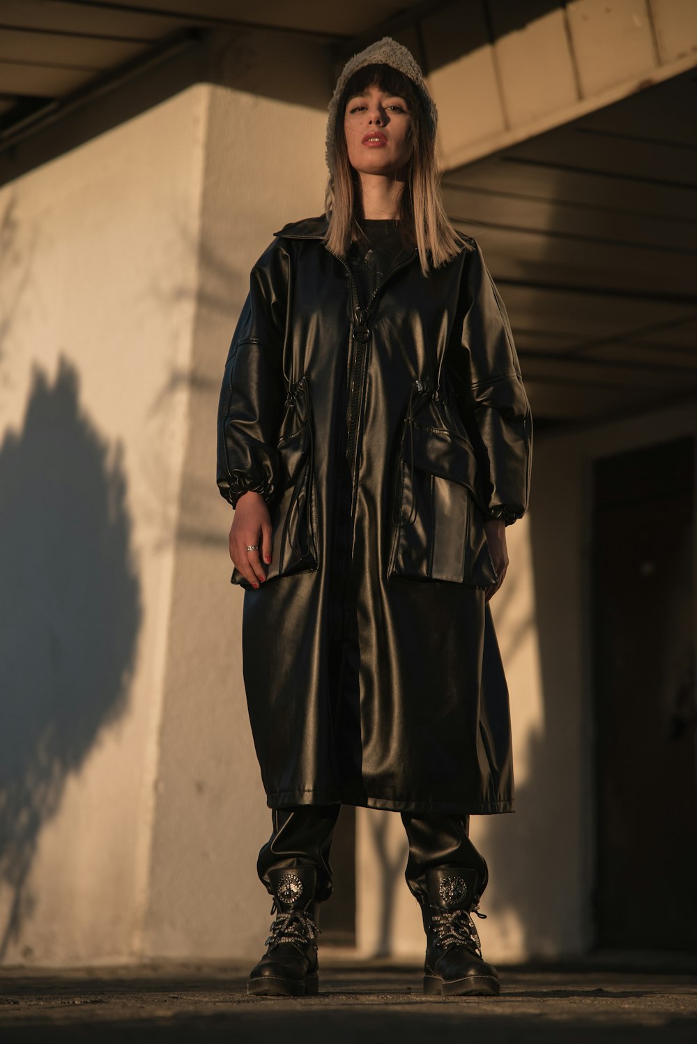 une femme vêtue d’un manteau et de bottes en cuir noir