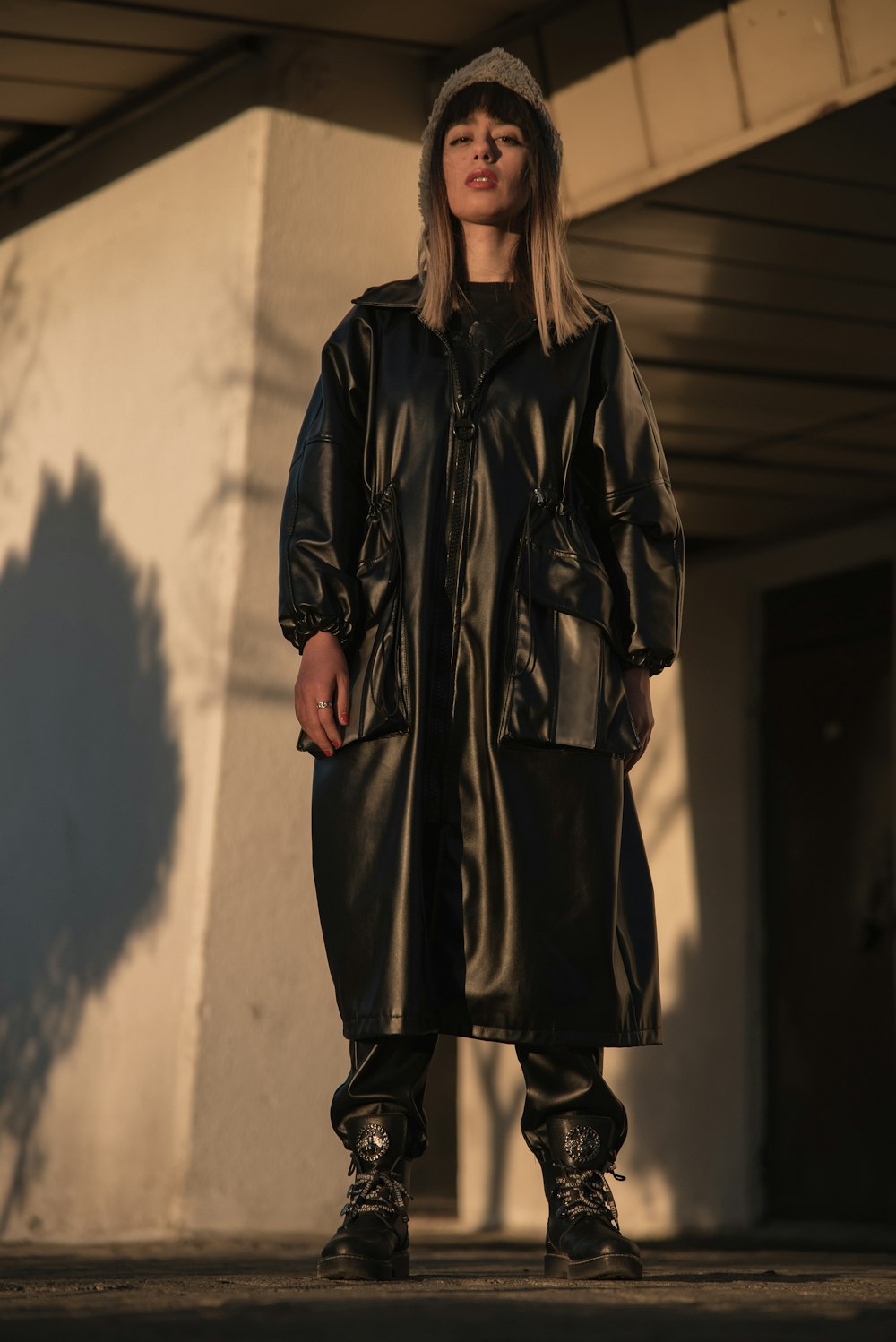 a woman wearing a black leather coat and boots