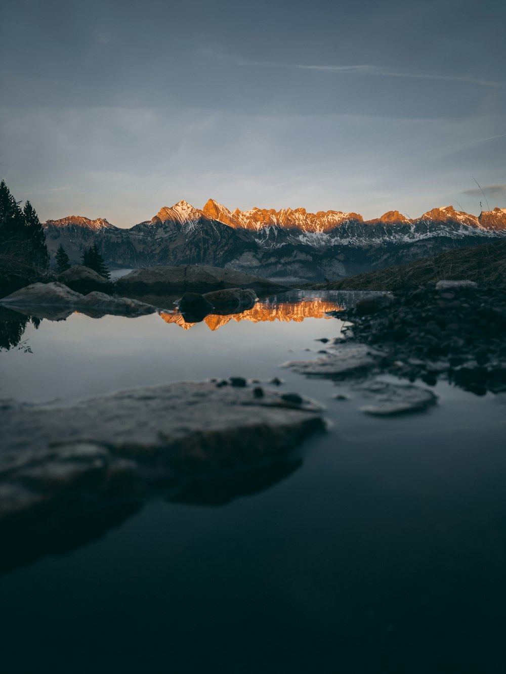 a mountain range with a body of water in the foreground