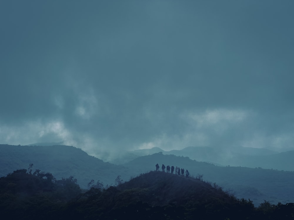 a group of people standing on top of a hill