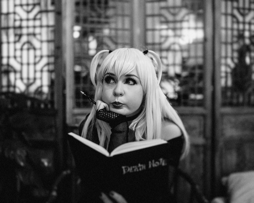 Una mujer con cabello largo y rubio está leyendo un libro