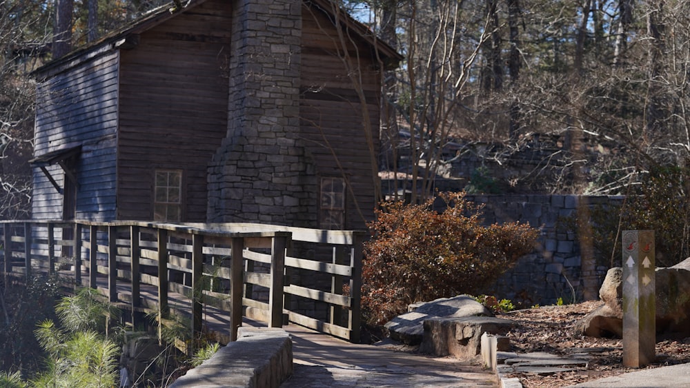 a wooden building in the woods with a fence around it