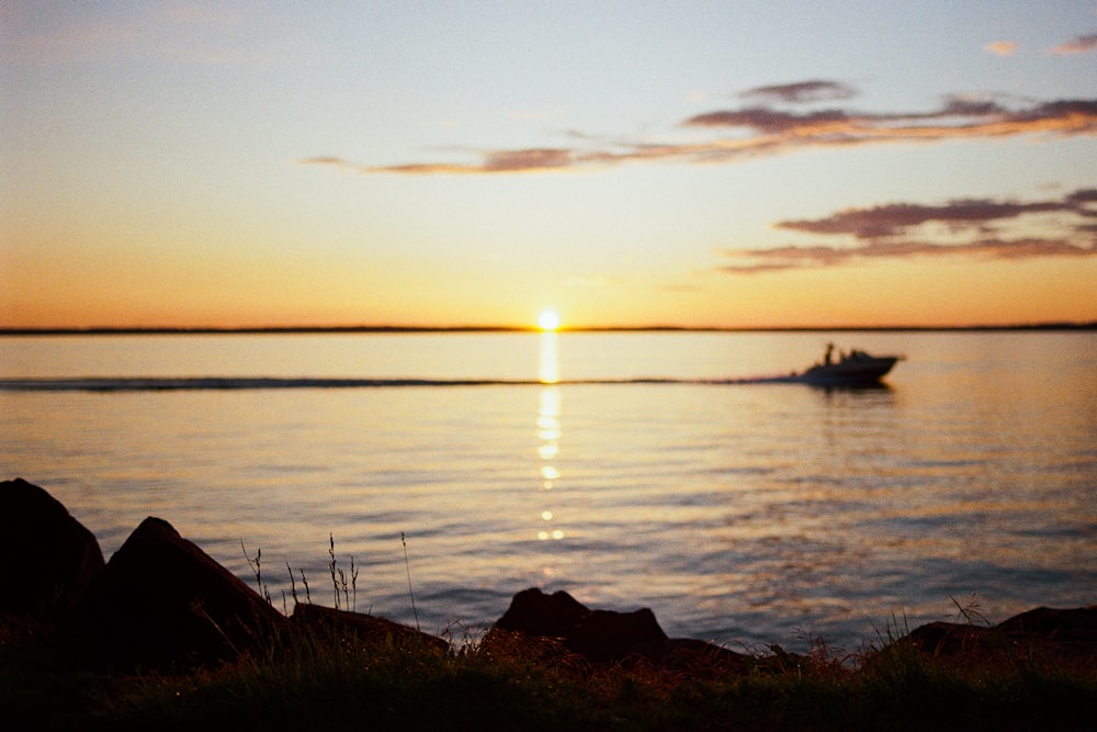 a boat is out on the water at sunset