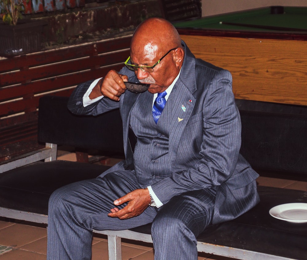 a man in a suit sitting on a bench