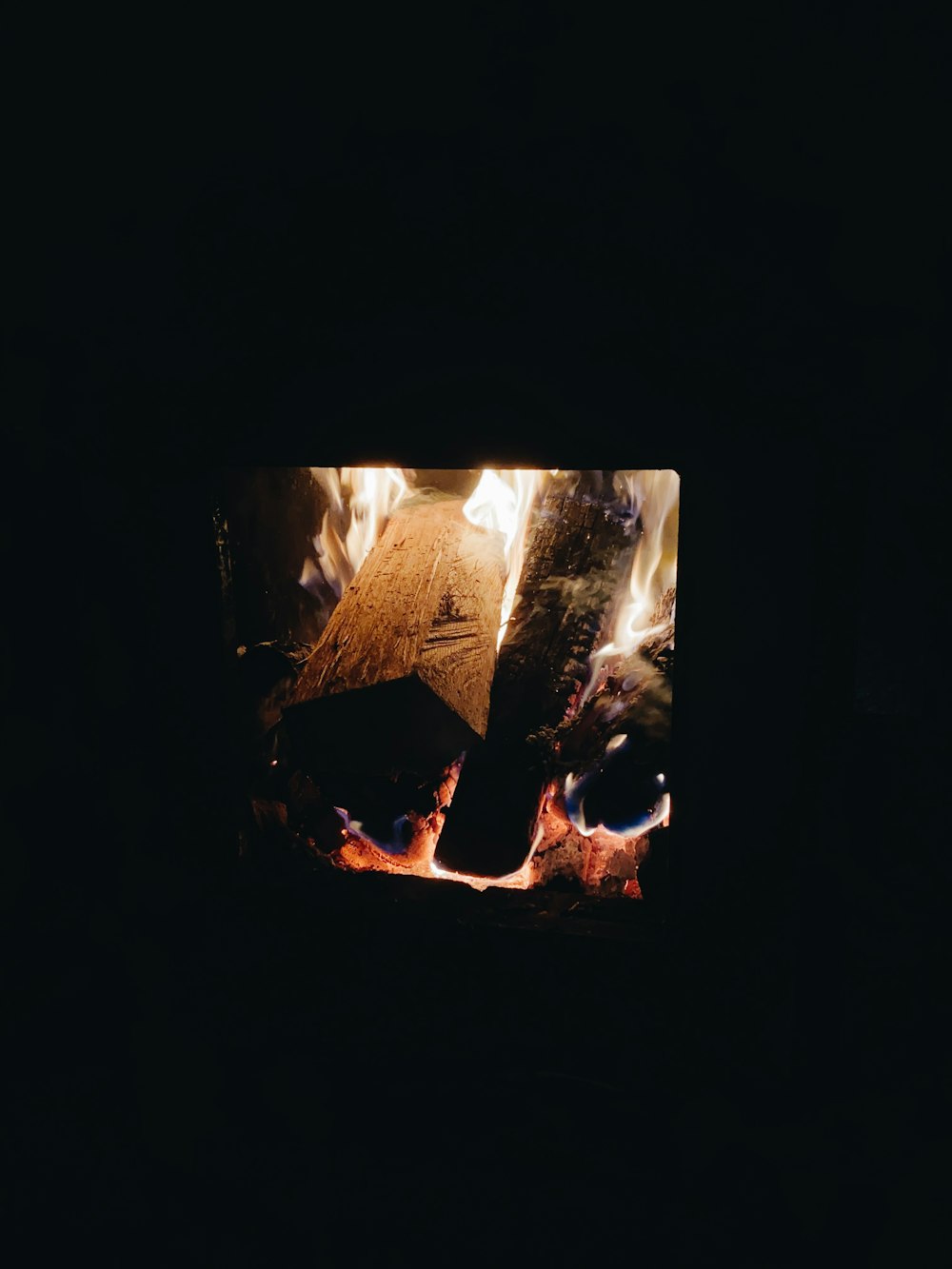 a fire burning in a fireplace with a pyramid in the background