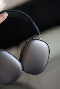 Close-up of a customer happily testing a sleek pair of wireless headphones.