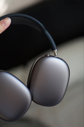 Close-up of skilled technicians assembling titanium alloy headphone shells in a clean manufacturing environment.