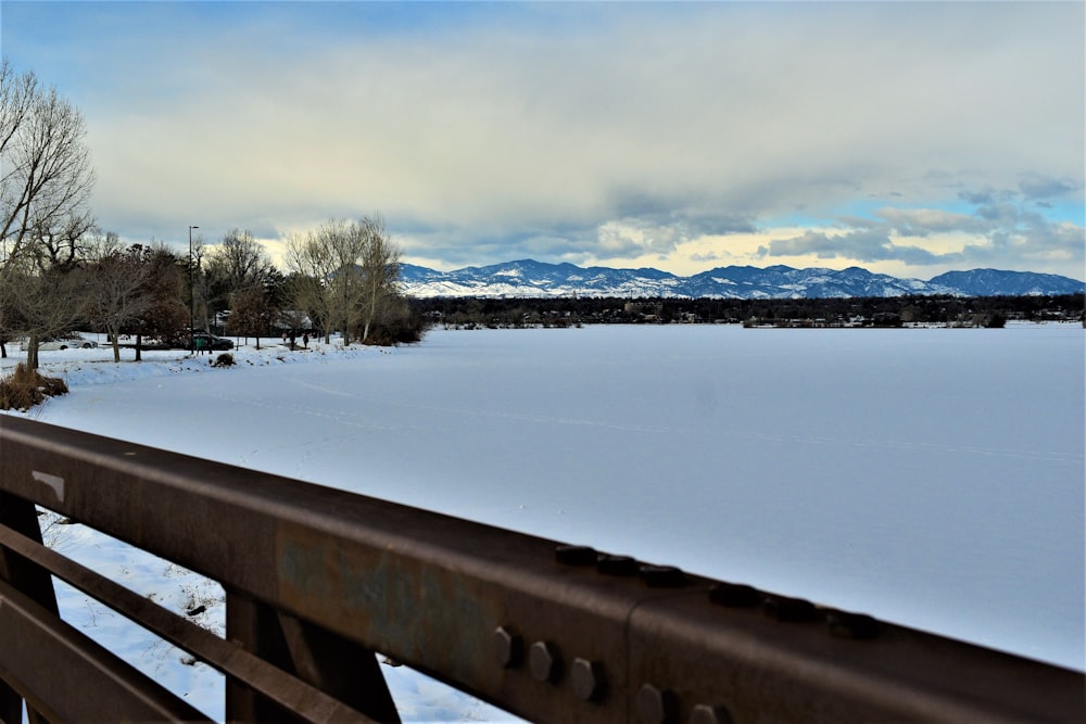 a snow covered field with mountains in the distance