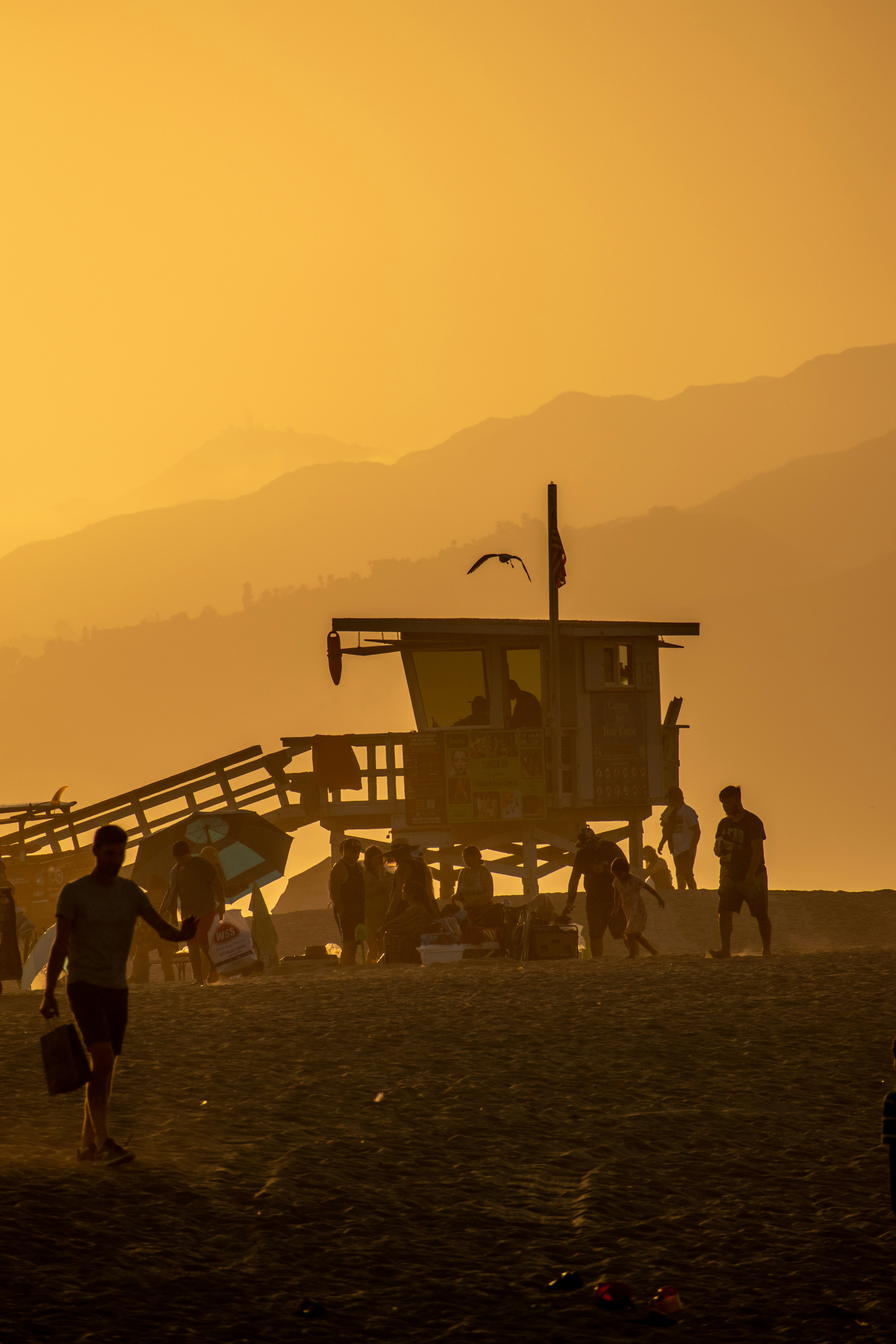 Un gruppo di persone in piedi sulla cima di una spiaggia sabbiosa