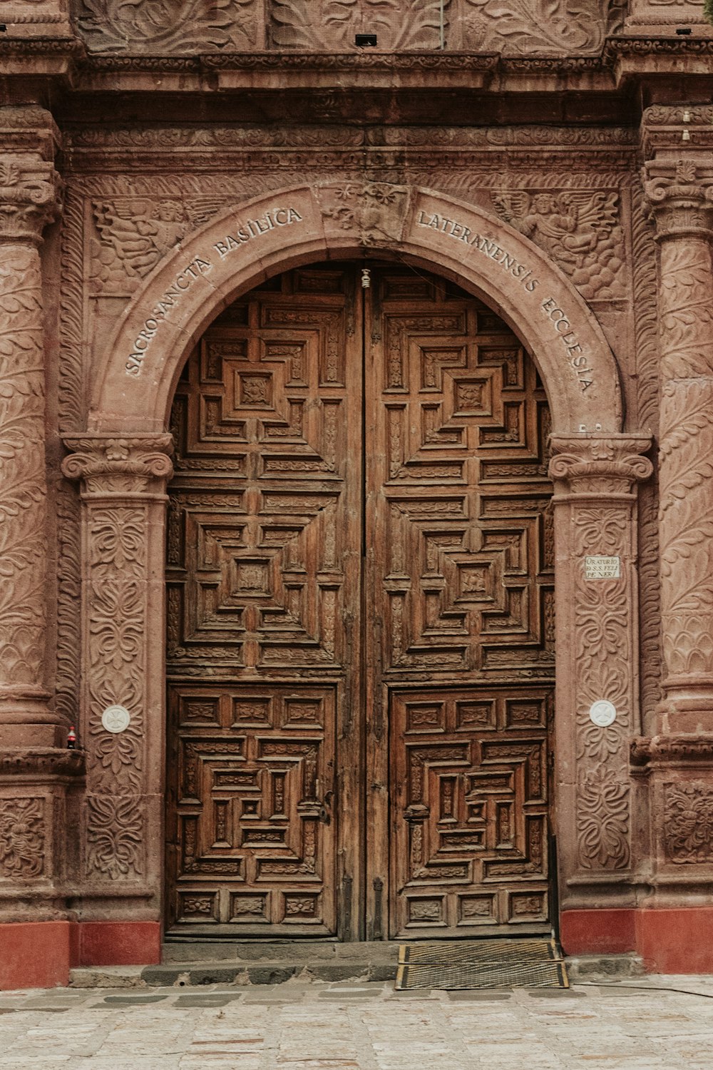 建物の前にある大きな木製のドアがいくつか