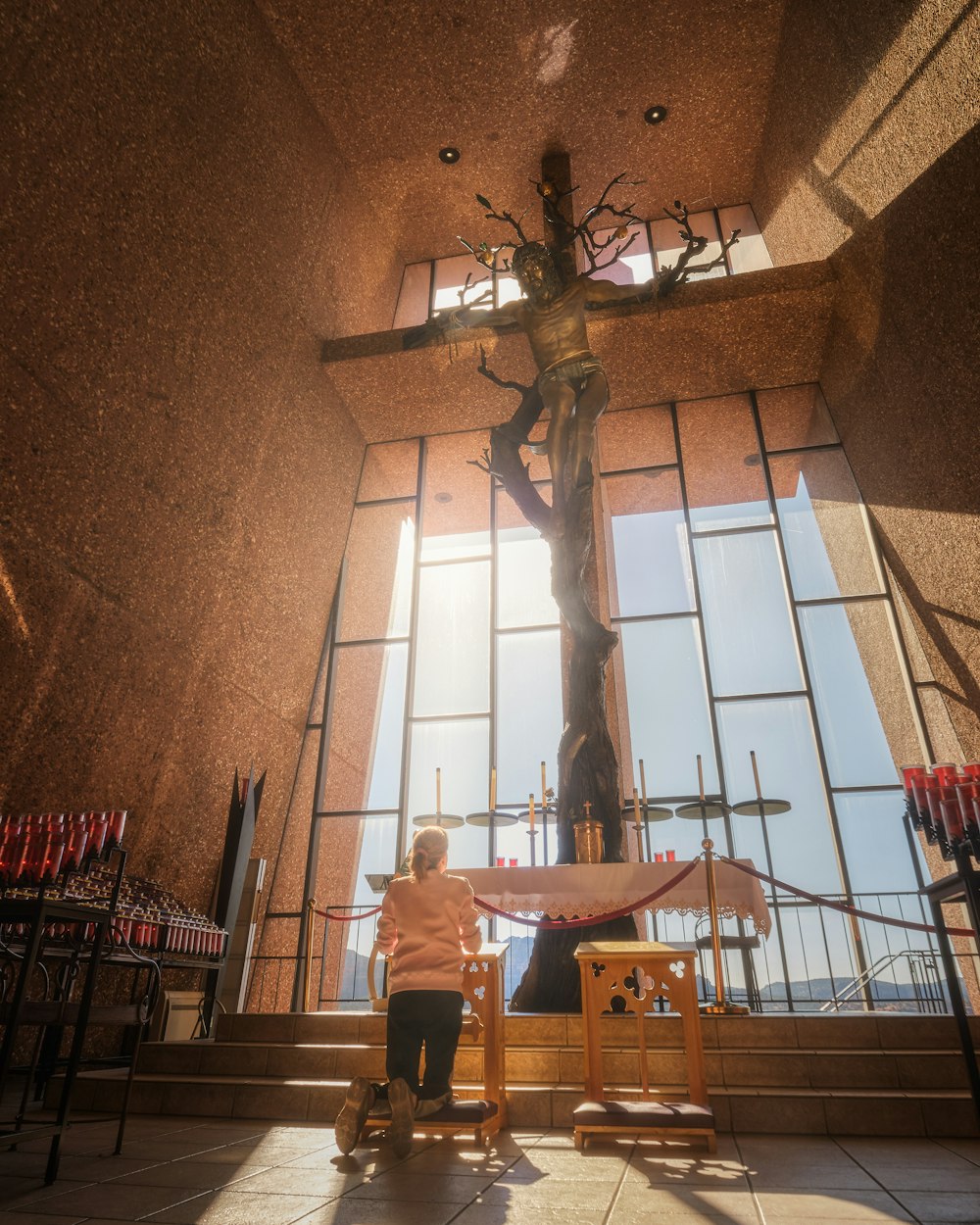 a woman standing in front of a cross in a church