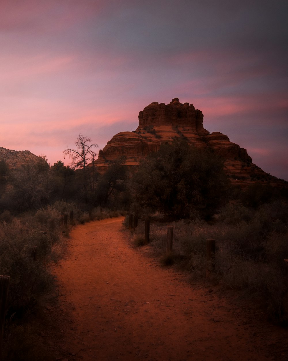 a dirt path leading to a large rock formation