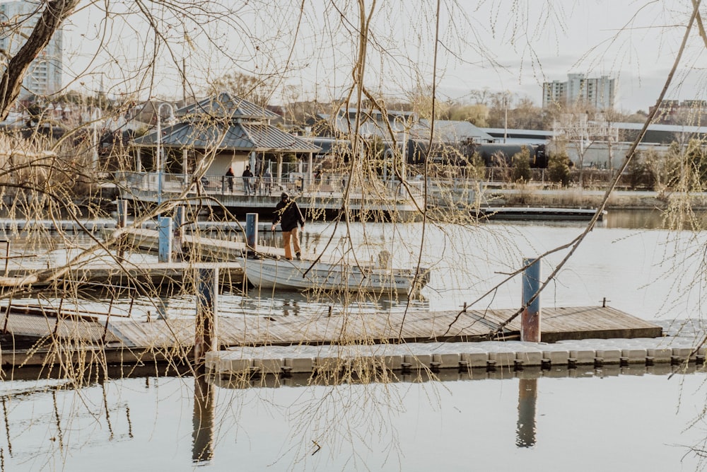 a man standing on a dock next to a body of water