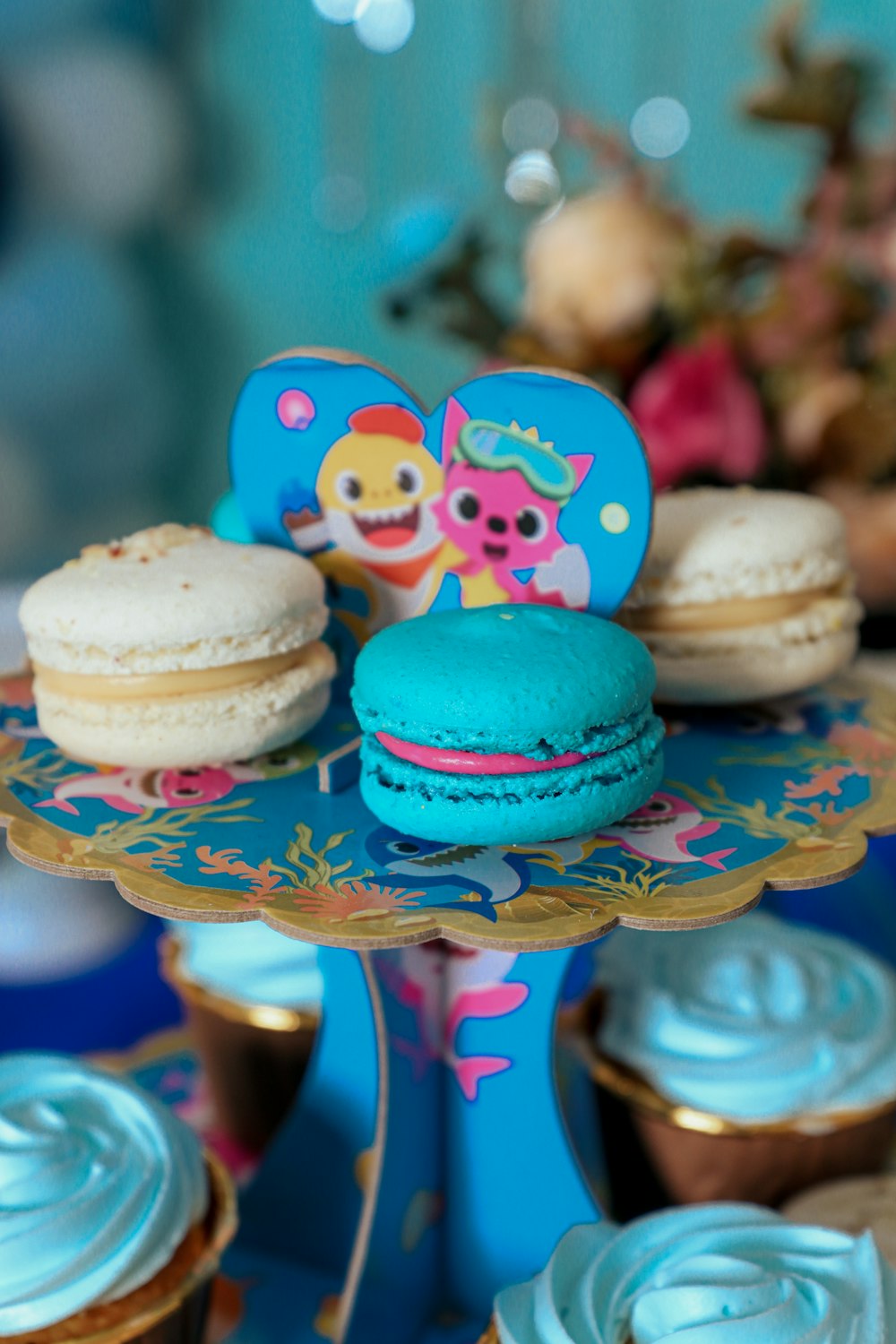 a table topped with cupcakes and macaroons