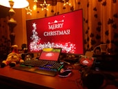 Festive holiday decorations next to a computer displaying NFT artwork creation.