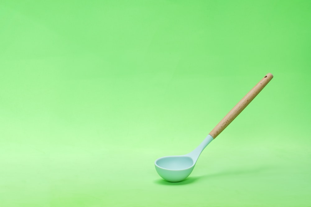 a spoon with a wooden handle on a green background
