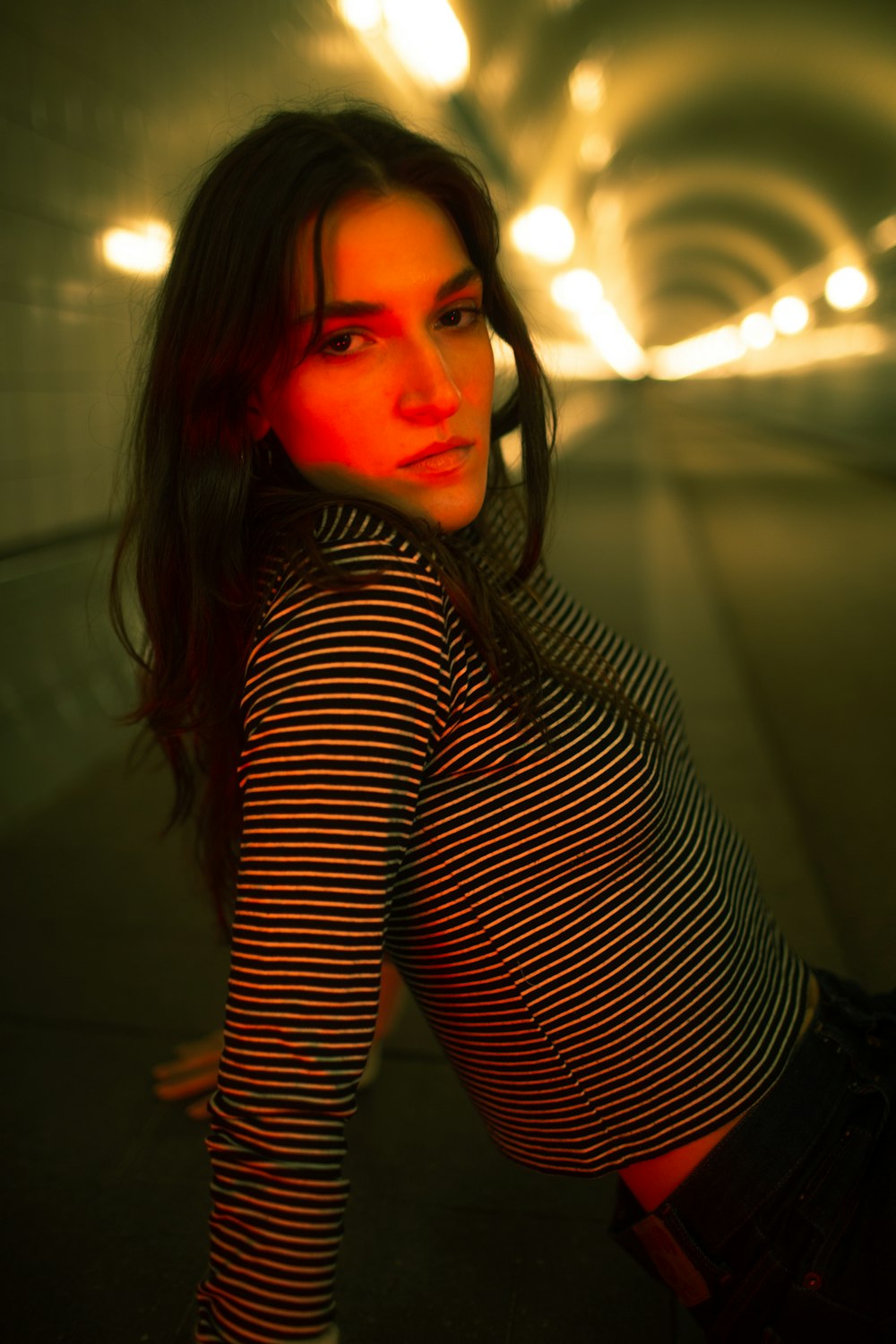 a woman is posing for a picture in a tunnel