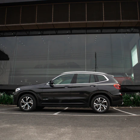 A sleek security vehicle parked in front of a prestigious business complex, ready for rapid response.