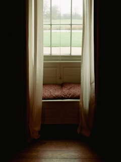 A serene corner featuring plush cushions and soft natural light filtering through sheer curtains.