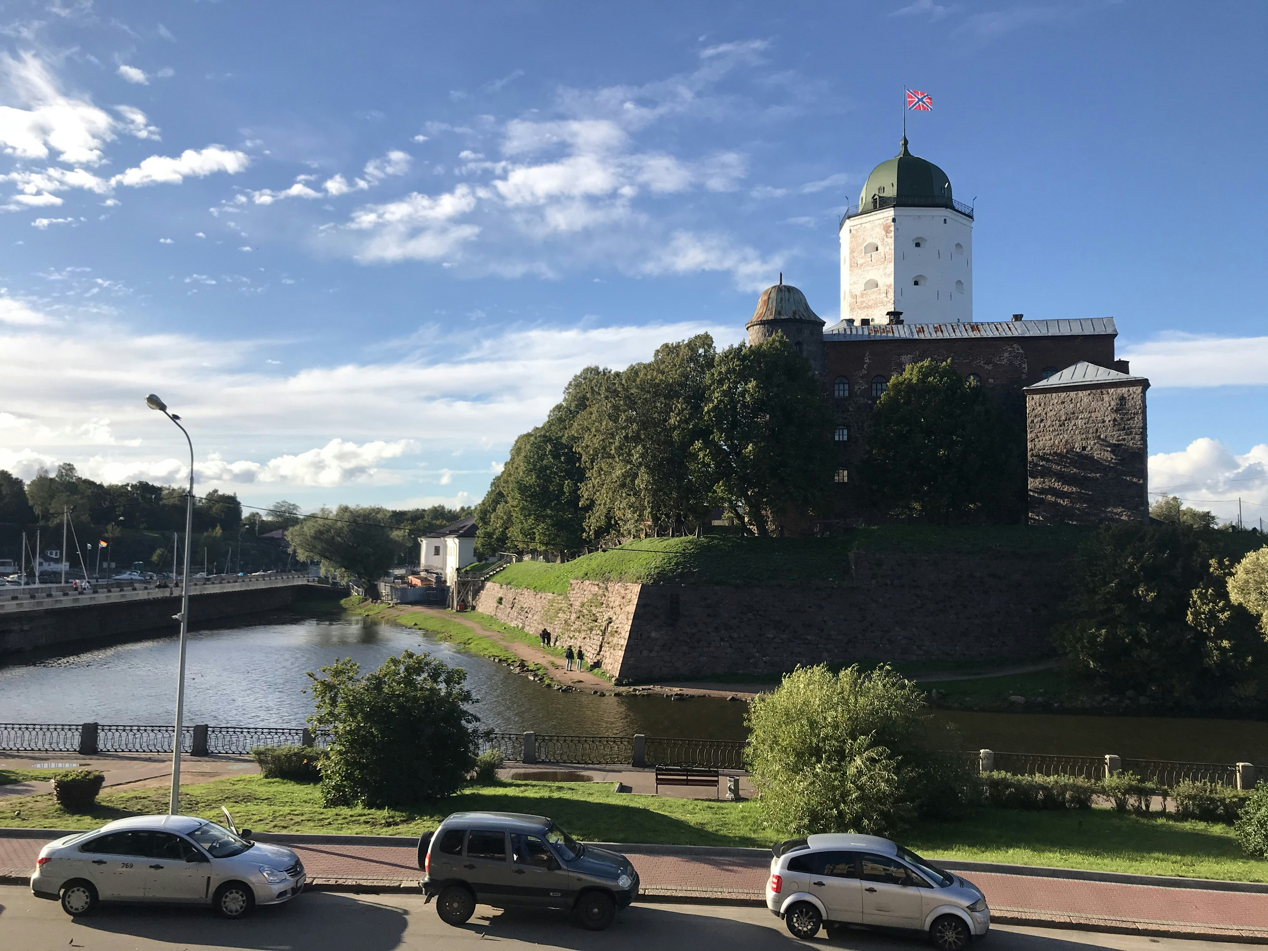 three cars parked on the side of a road next to a river