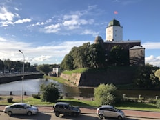three cars parked on the side of a road next to a river