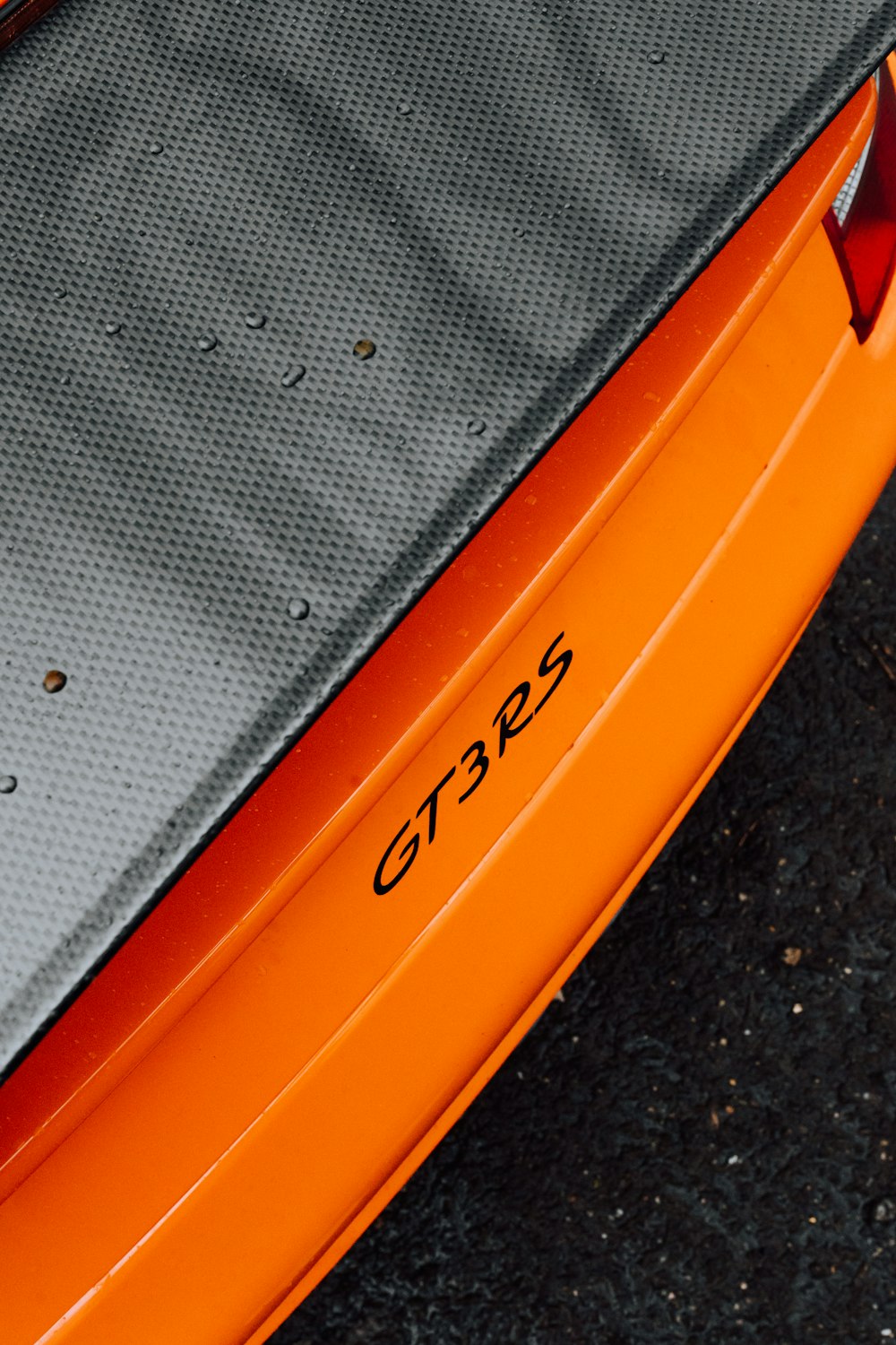 a close up of the rear end of an orange sports car