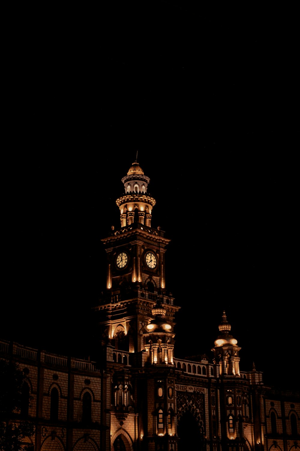 a large building with a clock tower lit up at night