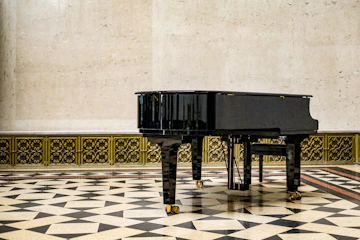 Elegant black grand piano illuminated by warm spotlight in a minimalist room