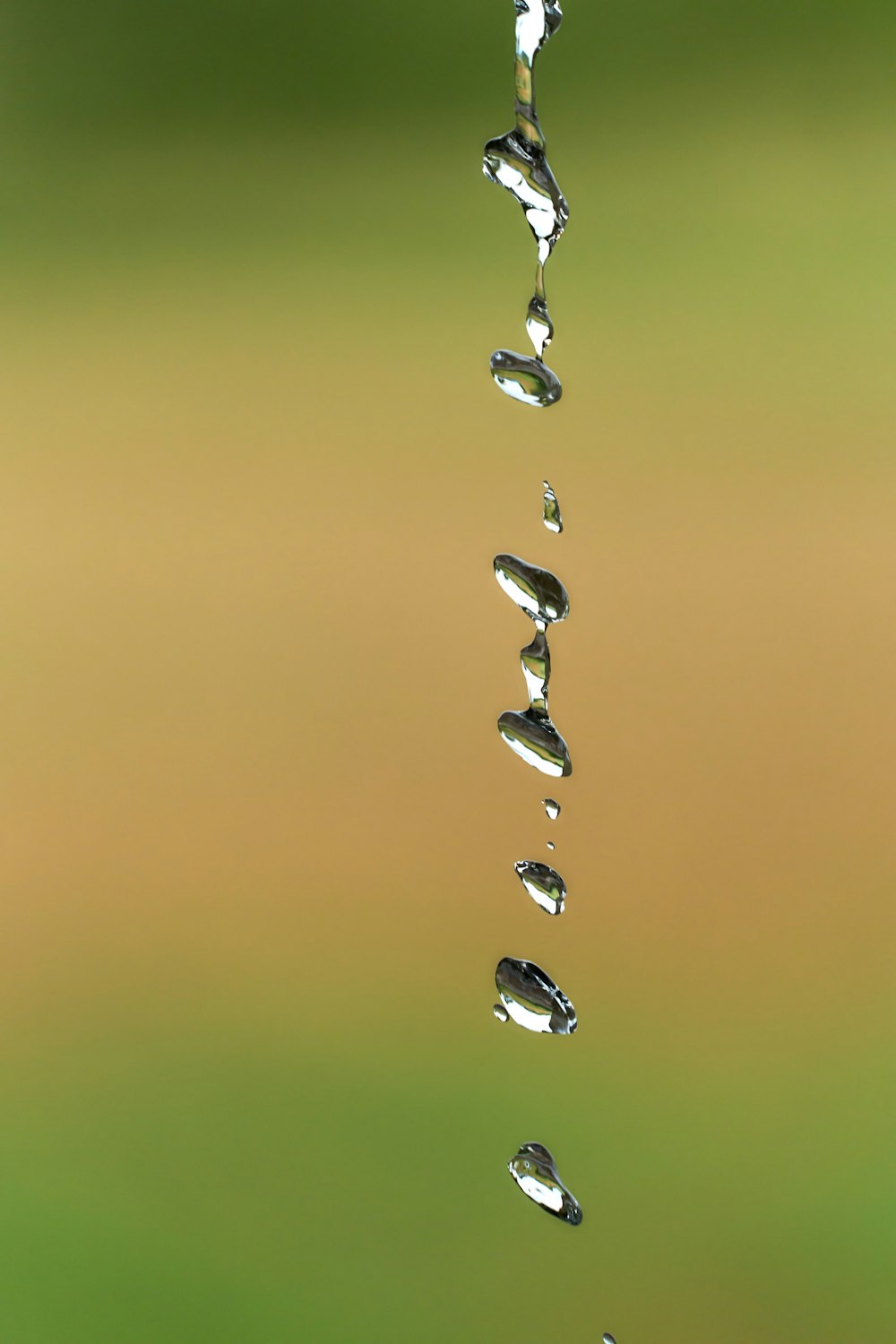 a group of water droplets hanging from a faucet