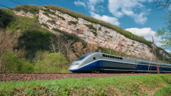 a blue and white train traveling down train tracks