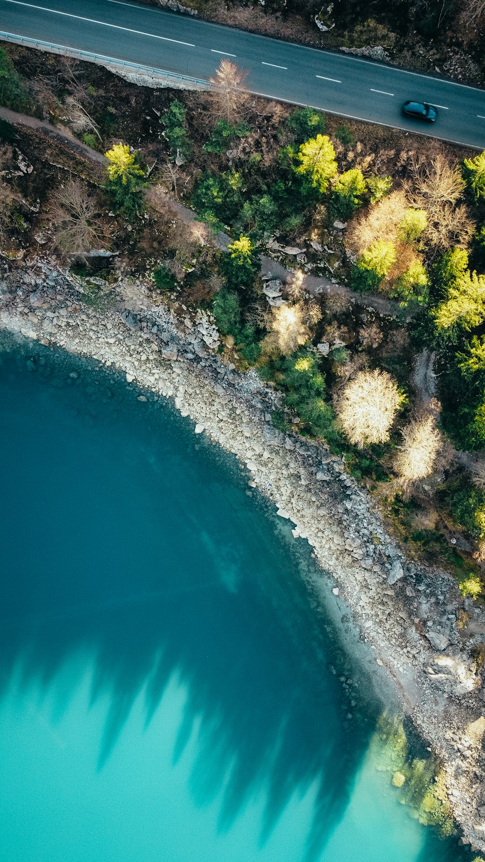 an aerial view of a road and a body of water