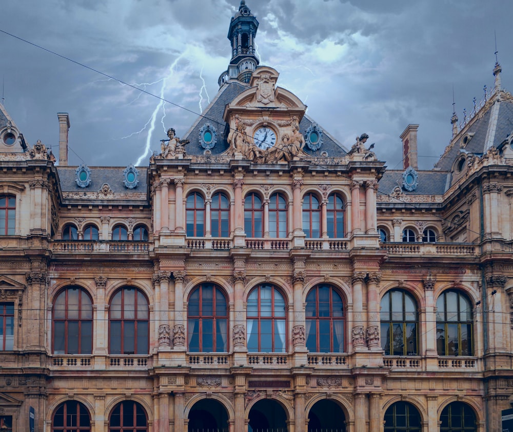 un grand bâtiment avec une horloge sur le dessus