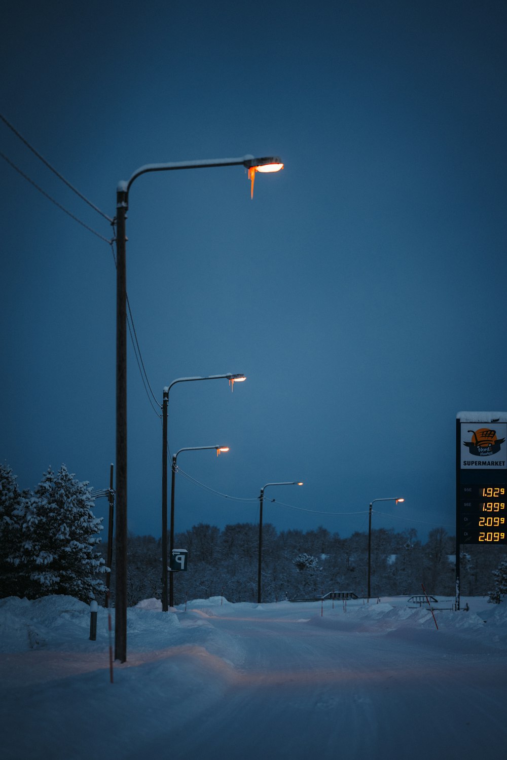 a street light in the middle of a snowy street