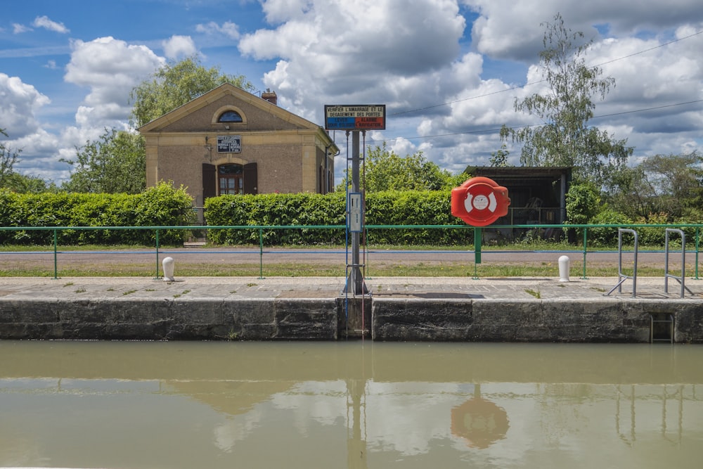 a red stop sign sitting on the side of a river