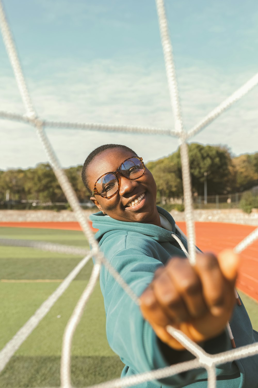 a man in a blue jacket is holding a soccer net