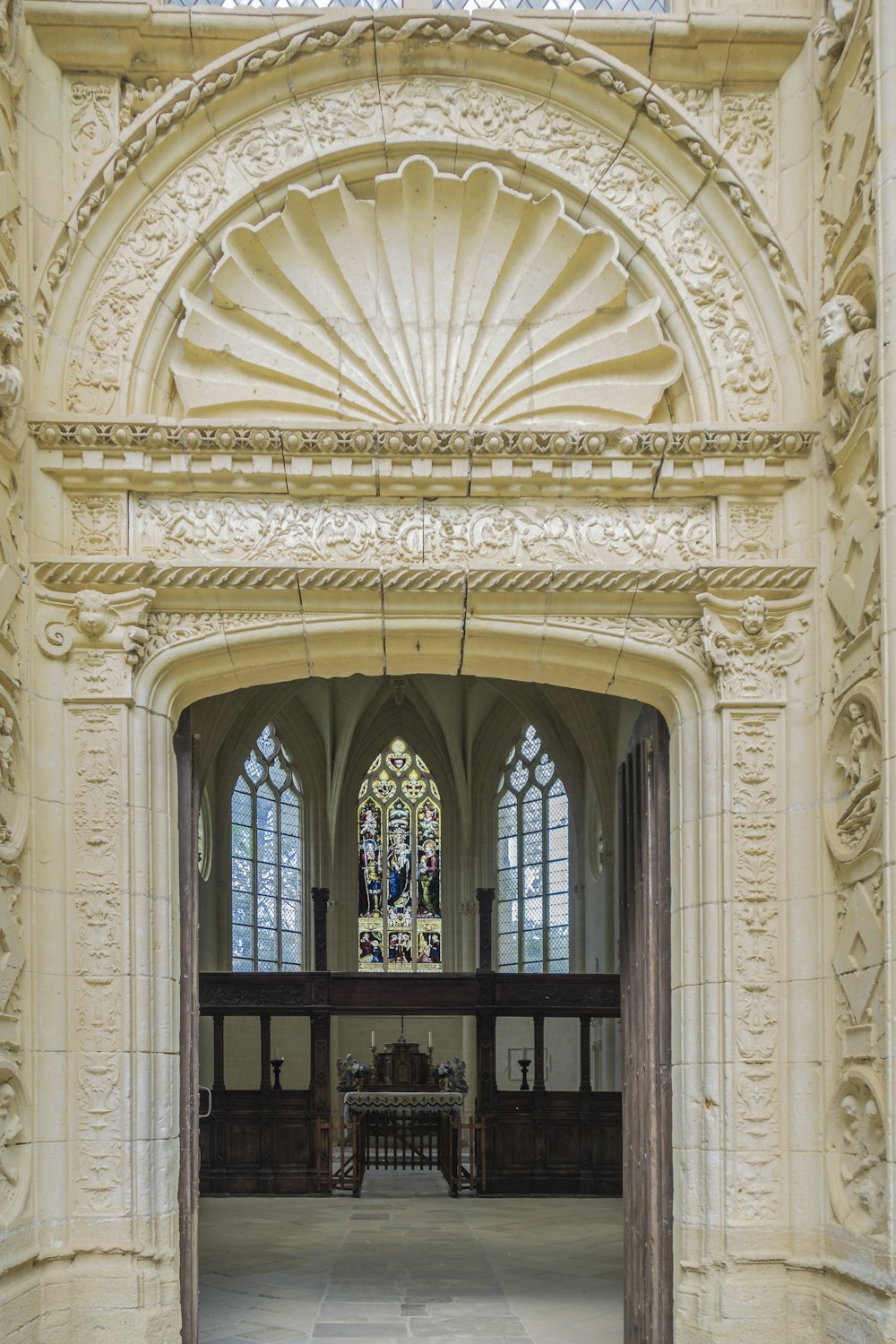 a church with a large arched doorway and stained glass windows