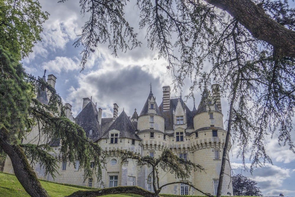 um grande castelo branco sentado no topo de um campo verde exuberante