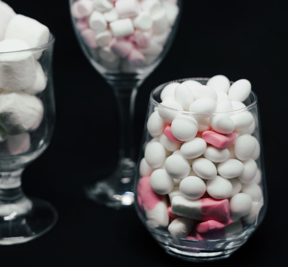 a couple of glasses filled with marshmallows on top of a table