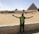 Smiling woman standing in front of the Pyramids of Giza at sunset.