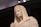 A classical marble statue depicting a serene figure draped in a cloak with a hood. The figure has a calm and thoughtful expression, and the craftsmanship highlights intricate details on the face and garments.