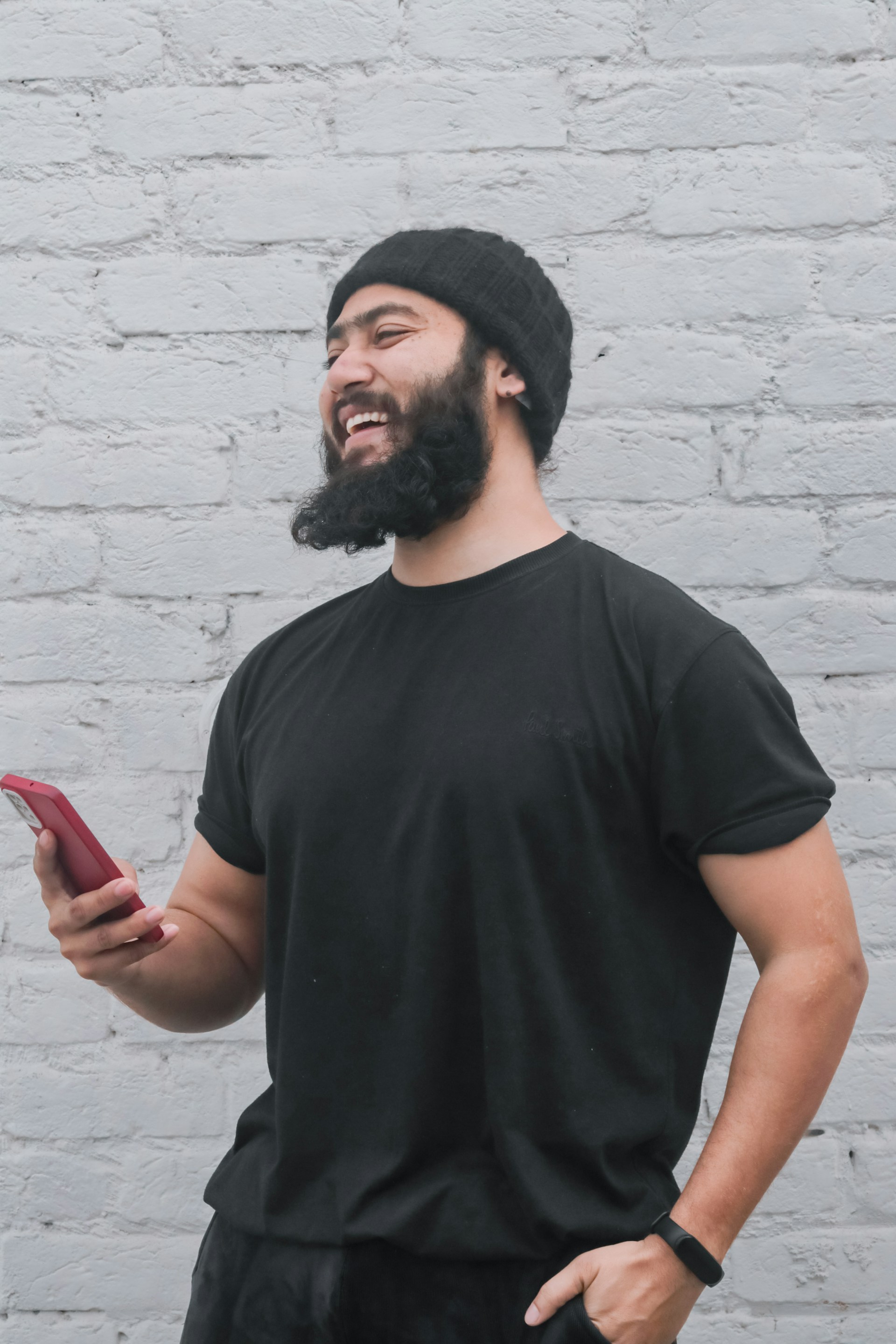 a man with a beard holding a cell phone
