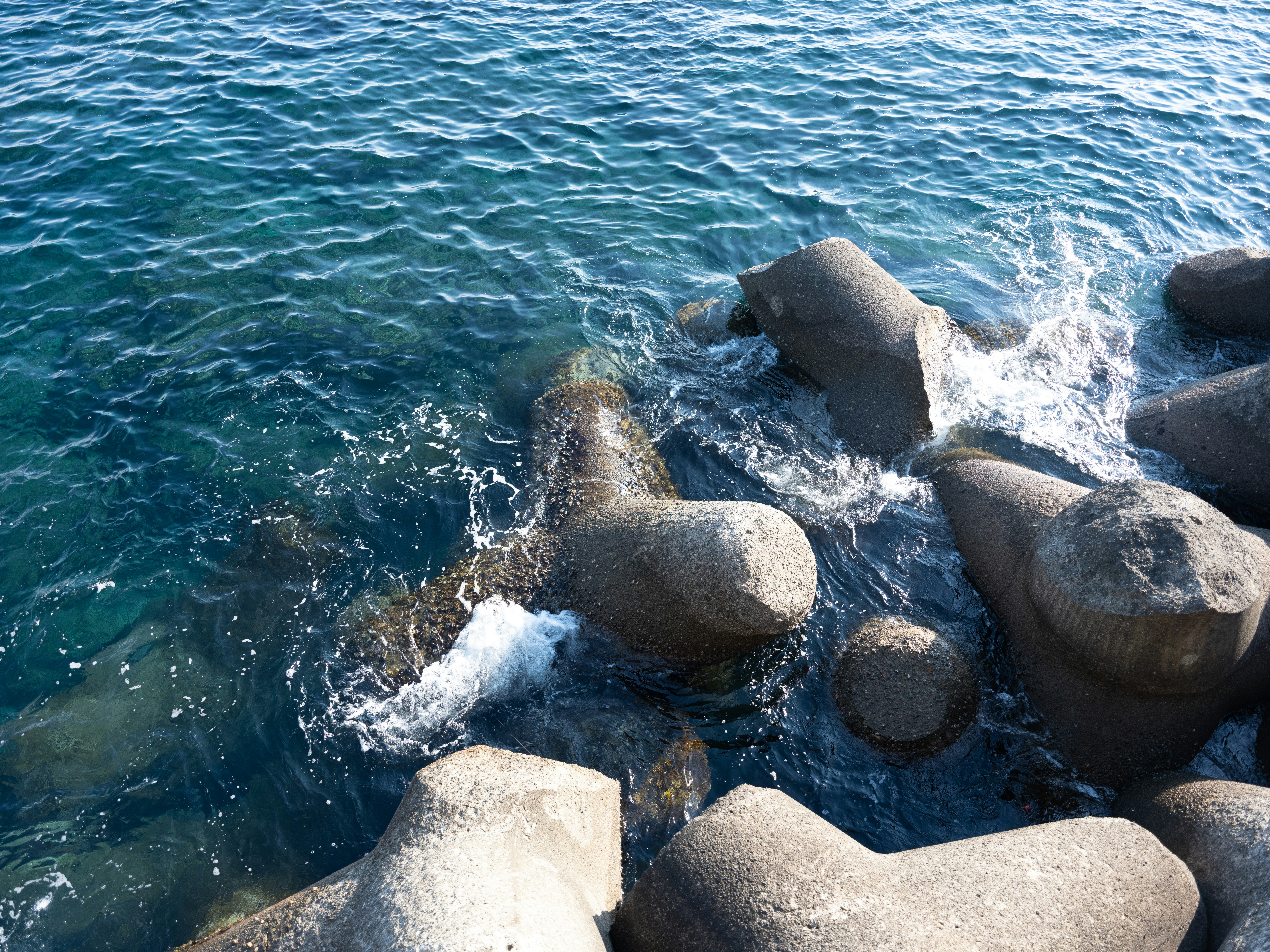 a body of water next to rocks and a body of water